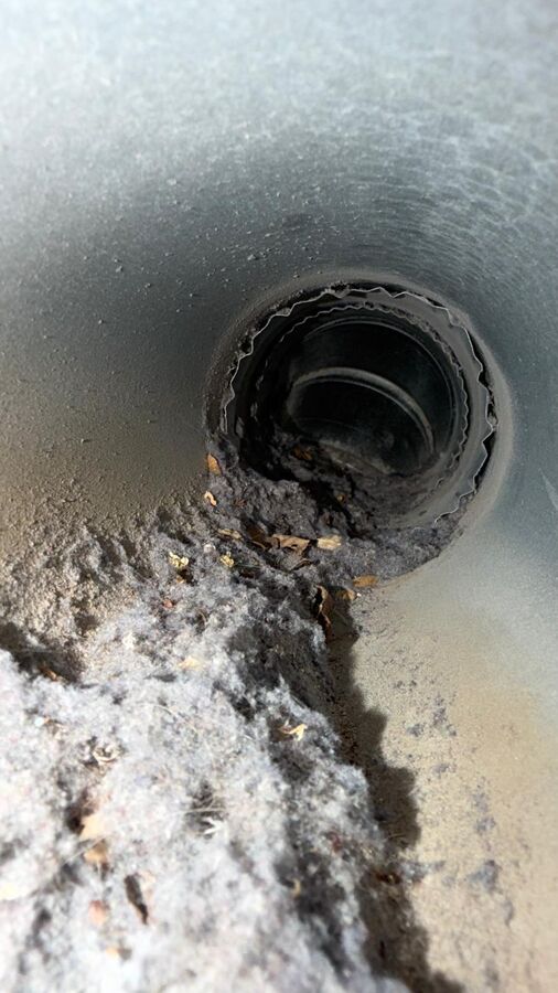 Lint and debris blocking a dryer vent joint before L&L's cleaning